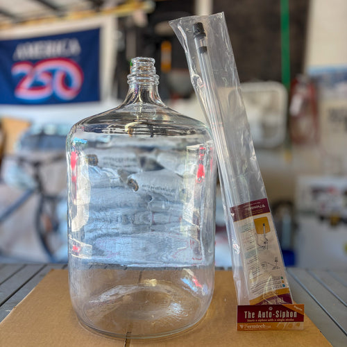 A 6 gallon glass carboy to show scale next to a 3/8” regular standard size auto siphon for homebrewing