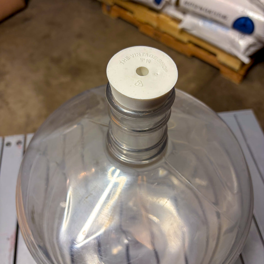 A clear plastic carboy with carboy stopper bung #10 installed