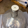 A clear plastic carboy with carboy stopper bung #10 installed