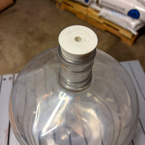 A clear plastic carboy with carboy stopper bung #10 installed