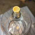 A glass carboy with a stopper bung attached