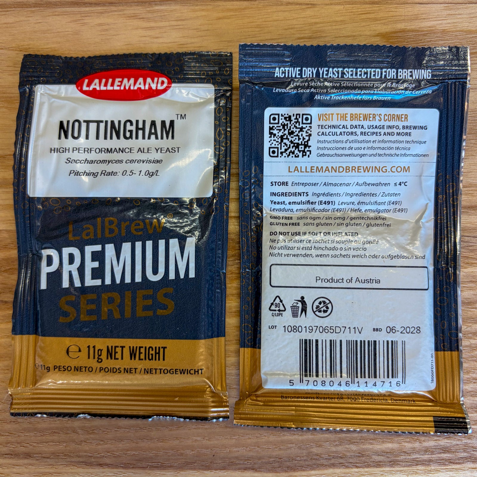 Two Lallemand LalBrew Premium Series Nottingham ale yeast packets shown side by side on a wooden surface, with the front and back packaging visible.
