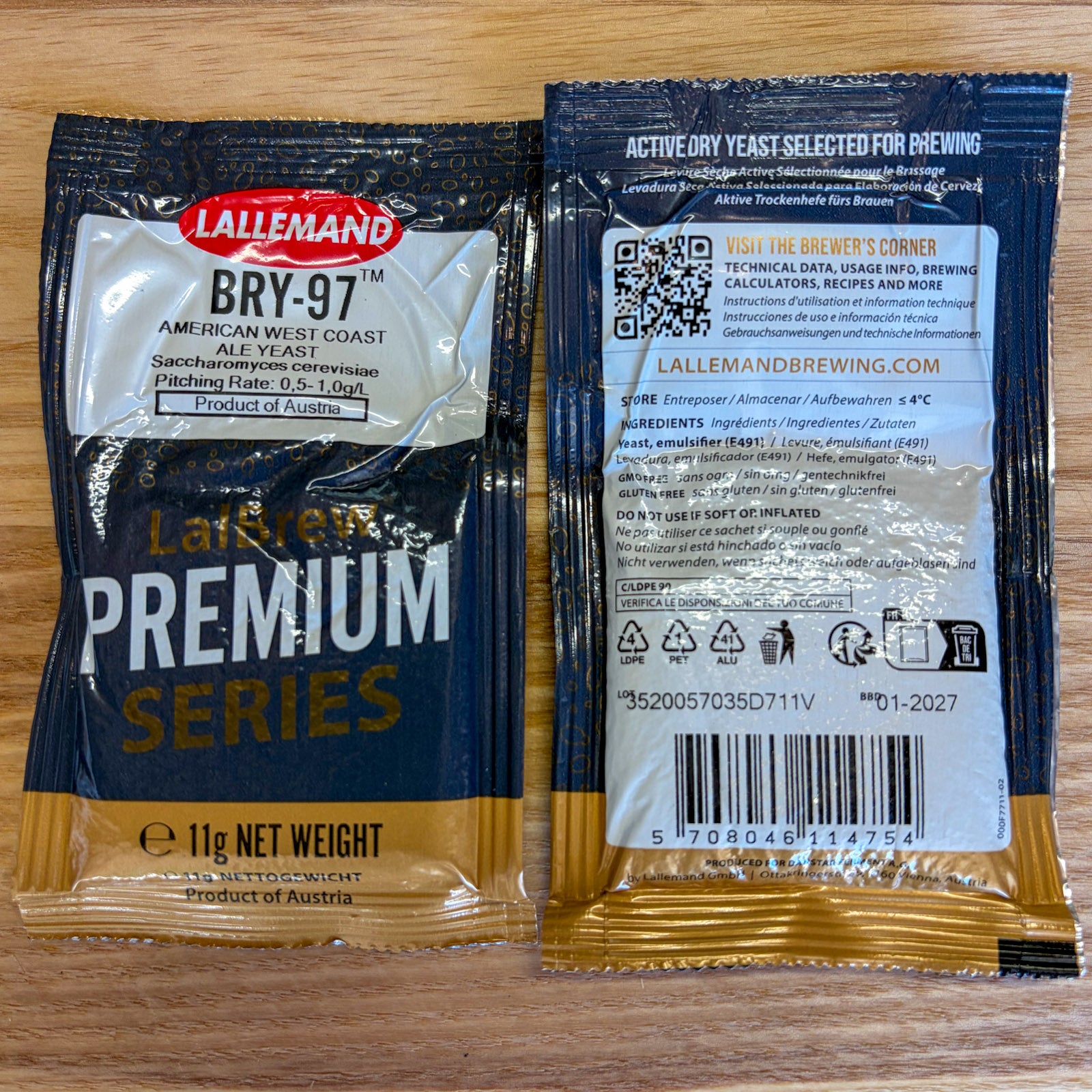 Two sealed packets of Lallemand BRY-97 American West Coast Ale Yeast shown on a wooden surface, with the front and back of the packaging visible.