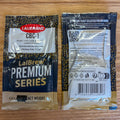 Two Lallemand CBC-1 LaBrew Premium Series yeast packets shown on a wooden surface, with the front and back packaging visible.
