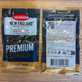 Two 11g packets of Lallemand New England Premium Series Ale Yeast shown side-by-side on a light wood background, displaying both the front and back packaging details.