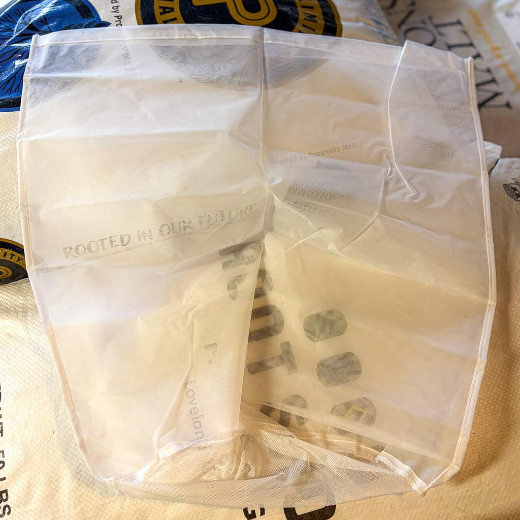 A large nylon bag used for brewing resting on grain sacks to compare size