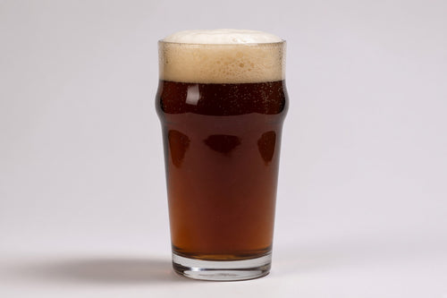 a pint glass of brown color beer with a tan head made with proximity regenmalt amber malted barley
