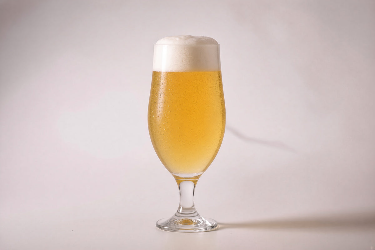 a glass of golden hazy beer showing 8 srm color and a large white head made with proximity regenmalt body builder malted barley