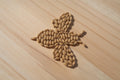 kernals of root shoot honey malted barley showing 20 lovibond color arranged in the shape of a bee on a wooden surface